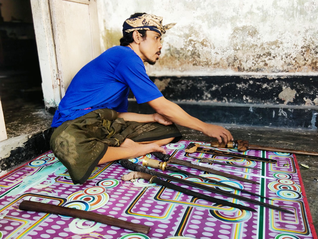Lalu Ramdhan mengamati keris-keris yang baru selesai dibuatnya.