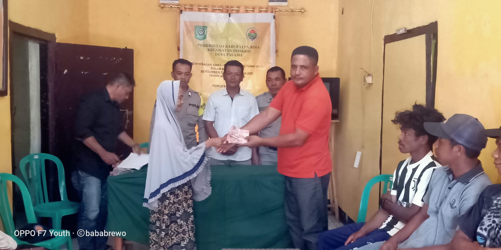BAGIKAN BLT: Kades Pala Gajali menyerahkan BLT kepada KPM di kantor Desa Palama, Kecamatan Donggo, Kabupaten Bima.(PEMDES PALAMA FOR LOMBOK POST)