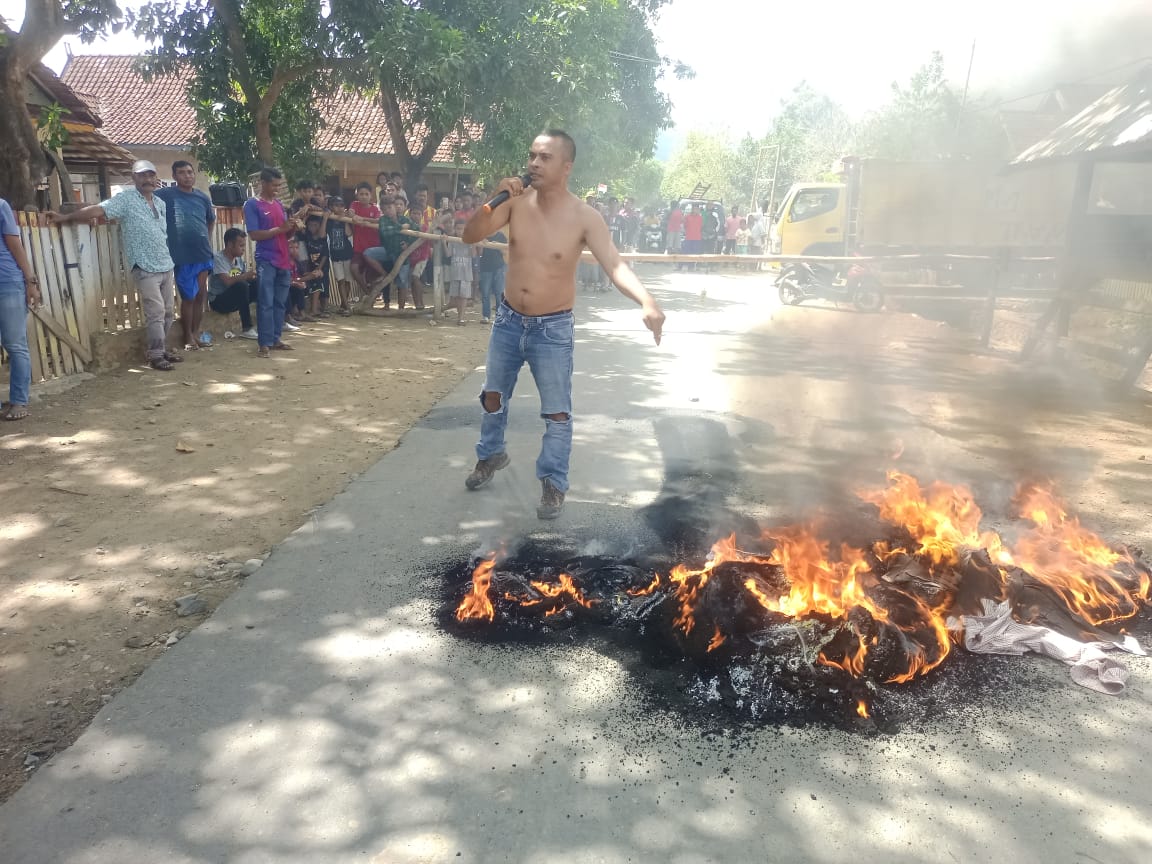 TUTUP JALAN: Salah seorang warga saat berorasi di jalan raya lintas Woro-Campa, Kabupaten Bima, minggu (19/11).(FIRMAN/LOMBOK POST)
