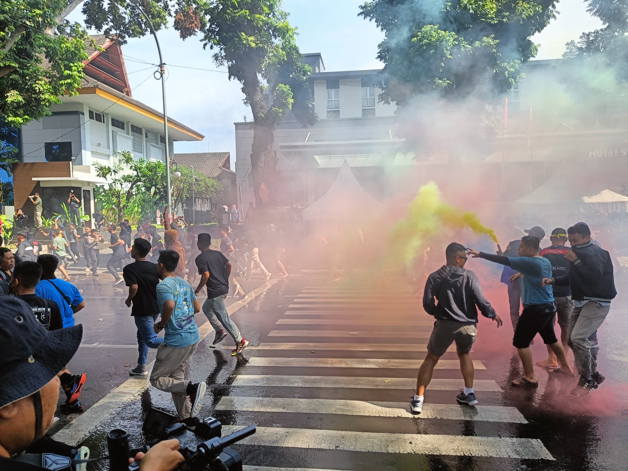 SIMULASI: Masa aksi berusaha menembus barikade pertahanan aparat kepolisian di tengah kepulan gas air mata, kemarin (23/11).