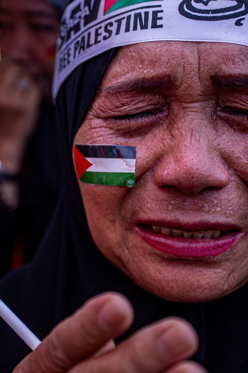 Seorang wanita memanjatkan doa untuk warga Palestina.
