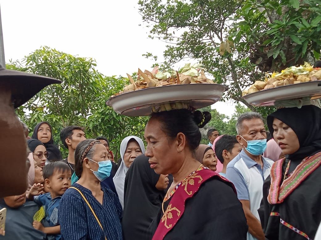 TRADISI: Masyarakat mengikuti tradisi perang topat dengan menyunggi satu dulang topat.(IST//LOMBOK POST)