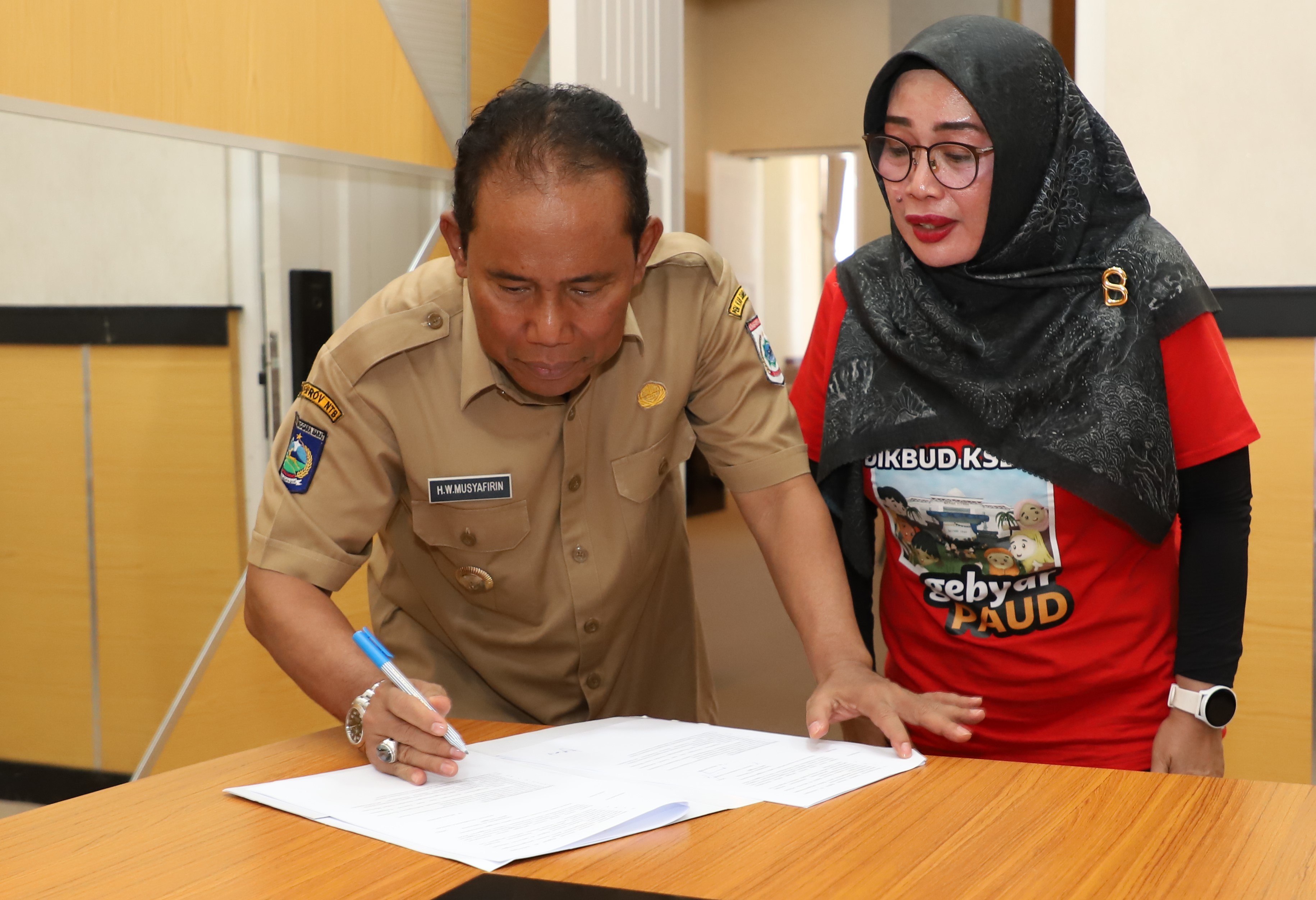 TEKEN SK: Bupati KSB HW Musyafirin menekan SK penggunaan aplikasi Go Jamu Sumbar didampingi Kadis Dikbud KSB Khusnarti. (FARUK/LOMBOK POST)