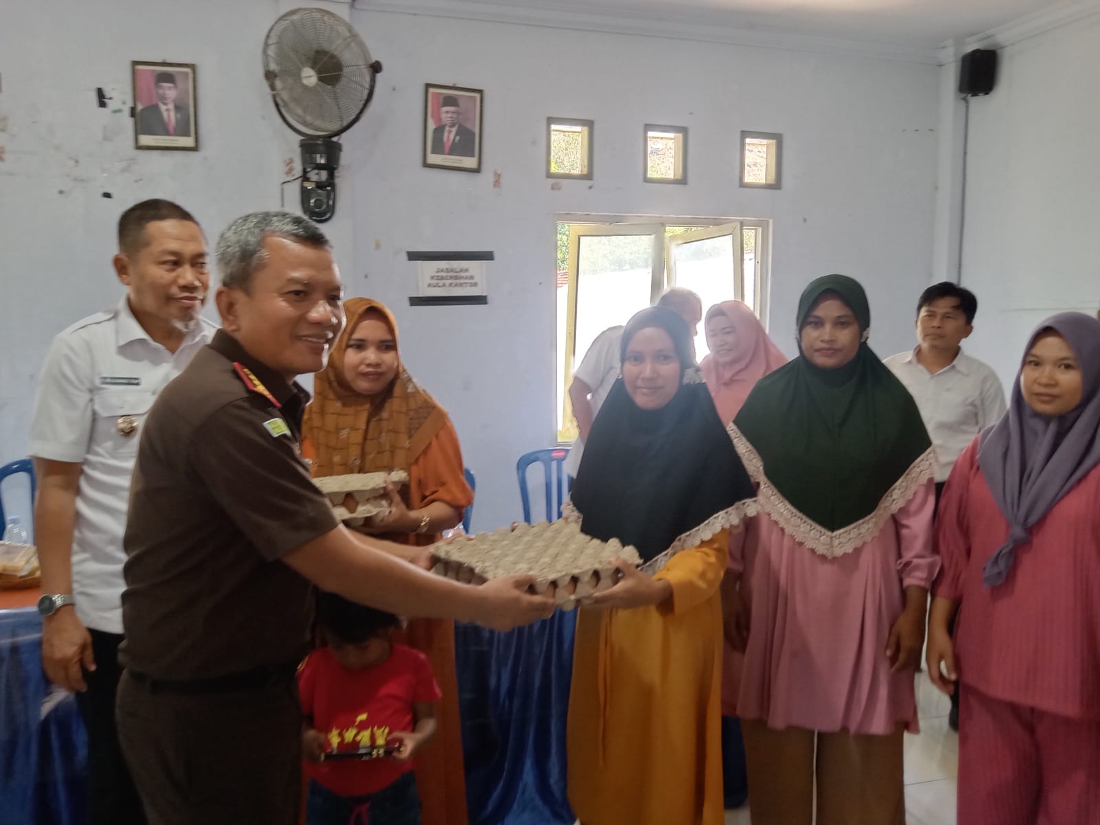 BAGIKAN TELUR: Kajari Bima Ahmad Hajar Zunaidi membagikan telur kepada warga Kelurahan Ntobo. (FIRMAN/LOMBOK POST)