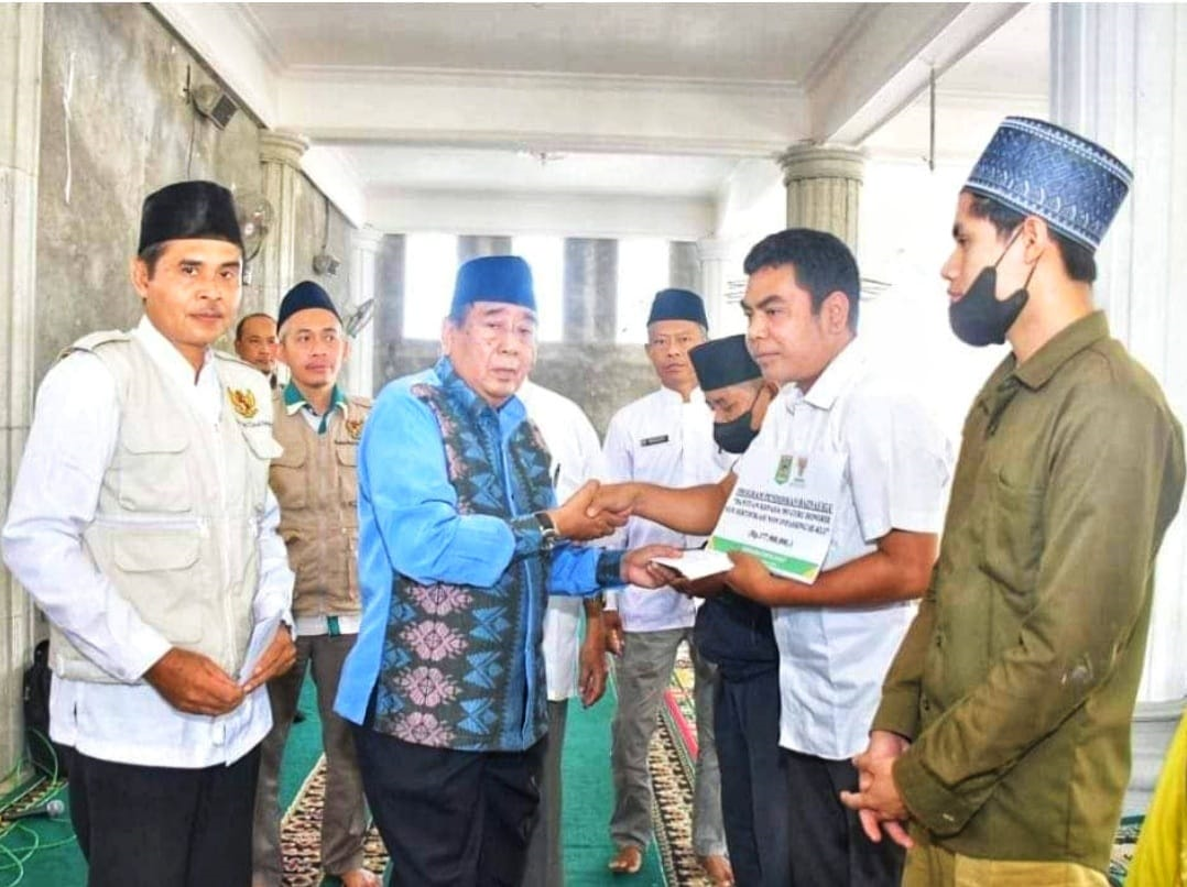 SALURKAN ZAKAT: Bupati Lombok Utara H Djohan Sjamsu (dia dari kiri) didampingi Tim Baznas KLU saat menyerahkan simbolis ZIS di Desa Gondang, Rabu (6/12).(RASYID FOR LOMBOK POST)