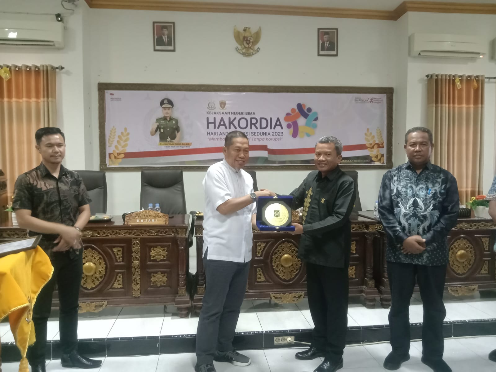 HAKORDIA: Kejari Bima Dr Ahmad Hajar Zunaidi menyerahkan plakat kepada Pj Wali Kota Bima Mohammad Rum usai peringati Hakordia. (FIRMAN/LOMBOK POST)