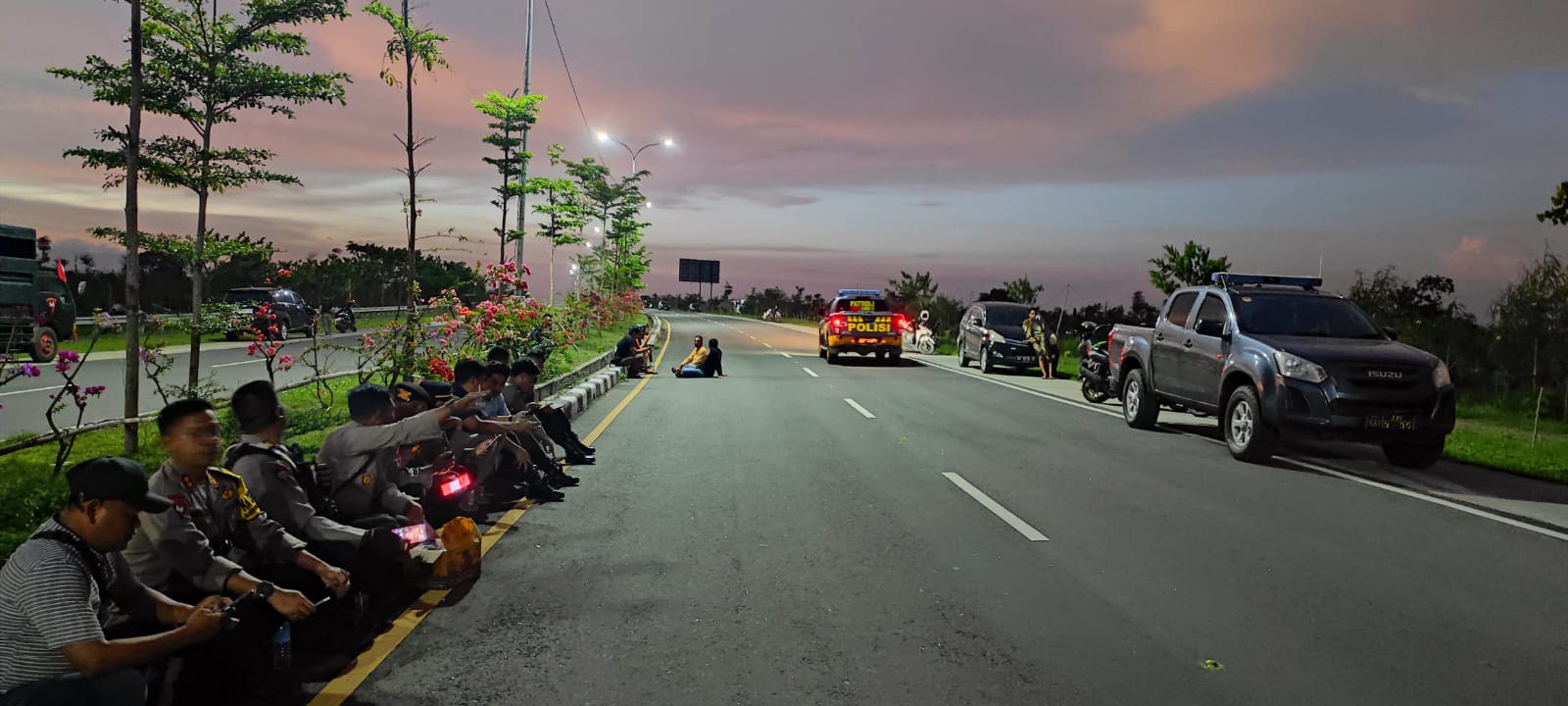 Personil Polres Loteng berjaga-jaga lokasi bentrok antar warga Desa Ketara dan Desa Segala Anyar pasca penangkapan terduga pencurian lampu reklame di jalan Bypass BIL-Mandalika, Jumat (8/12).
