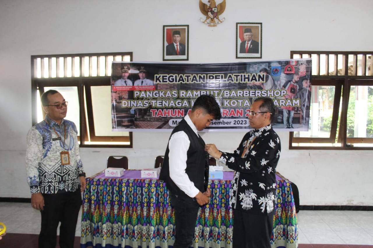 H Rudi Suryawan saat memasangkan rompi barber shop pada salah seorang peserta pelatihan.
