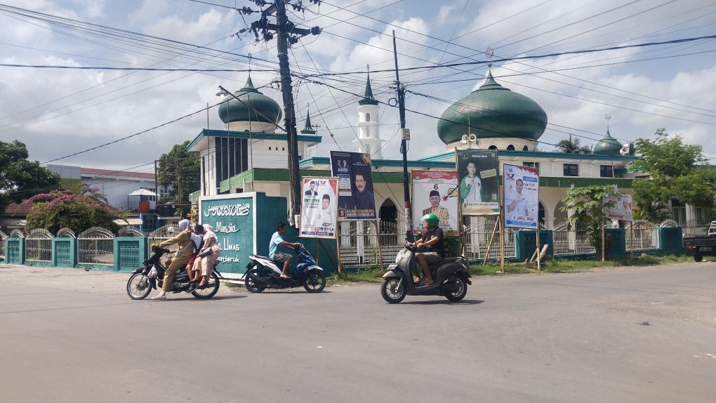 BUKAN TEMPATNYA: Sejumlah APK terpasang sangat dekat di Masjid Raden Umas Bonjeruk di Desa Bonjeruk, Kecamatan Jonggat, Loteng, Senin (11/12).