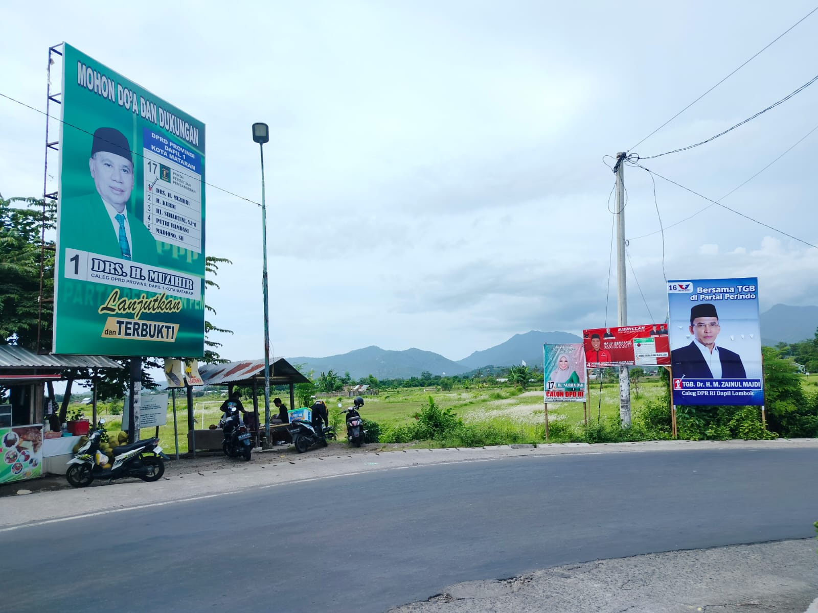 Baliho Ketua TPD Ganjar-Mahfud NTB Muzihir (paling kiri) dan Wakil Ketua TPN Ganjar-Mahfud TGB Zainul Majdi (paling kanan) terpasang di tikungan jalan Dakota, Rembiga, Mataram  (14/12).