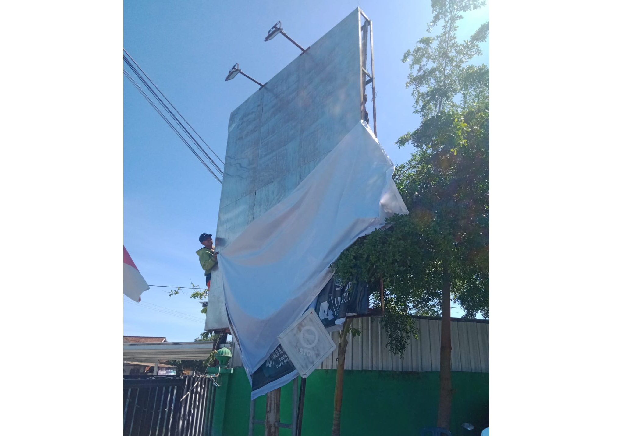BONGKAR MANDIRI: Salah satu tim caleg membongkar sendiri baliho sudah terpasang yang menyalahi aturan di Kecamatan Bayan, beberapa hari lalu.(BAWASLU KLU FOR LOMBOK POST)