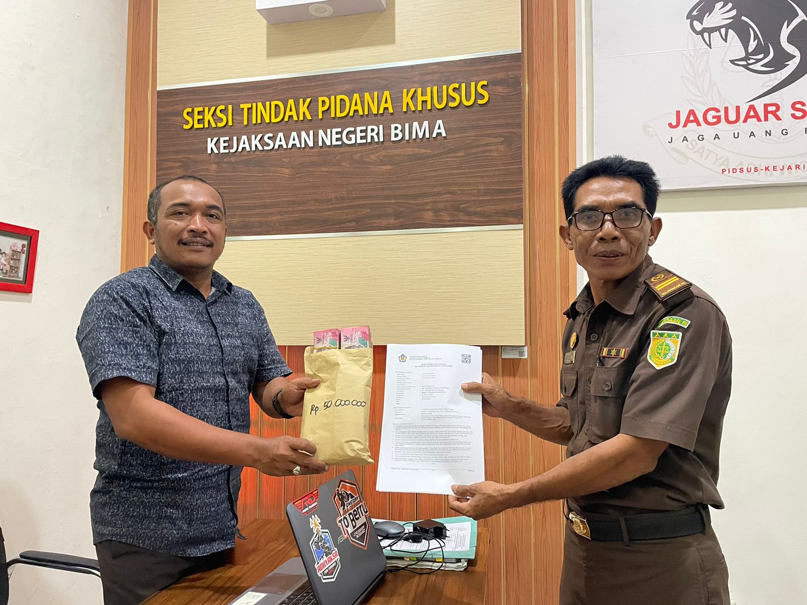 LUNAS DENDA: Plh Kepala Kejaksaan Negeri Bima Catur Hidayat (kiri) menerima pembayaran denda yang disetor terpidana korupsi bansos kebakaran Bima melalui JPU. (KEJARI BIMA FOR LOMBOK POST)