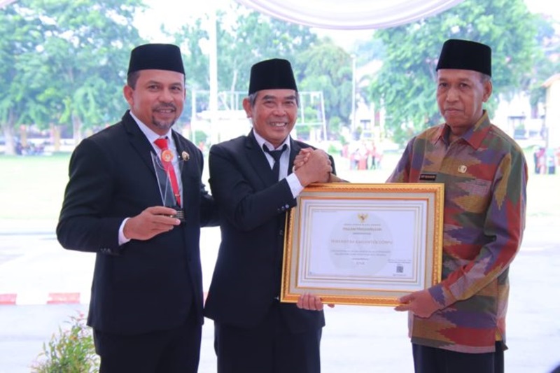 PENGHARGAAN: Kepala BKD dan PSDM Dompu Arif Munandar menyerahkan Piagam Penghargaan dari KASN kepada Wabup Dompu Syahrul Parsan disaksikan Bupati Dompu Kader Jaelani.(DOK Pemkab Dompu)