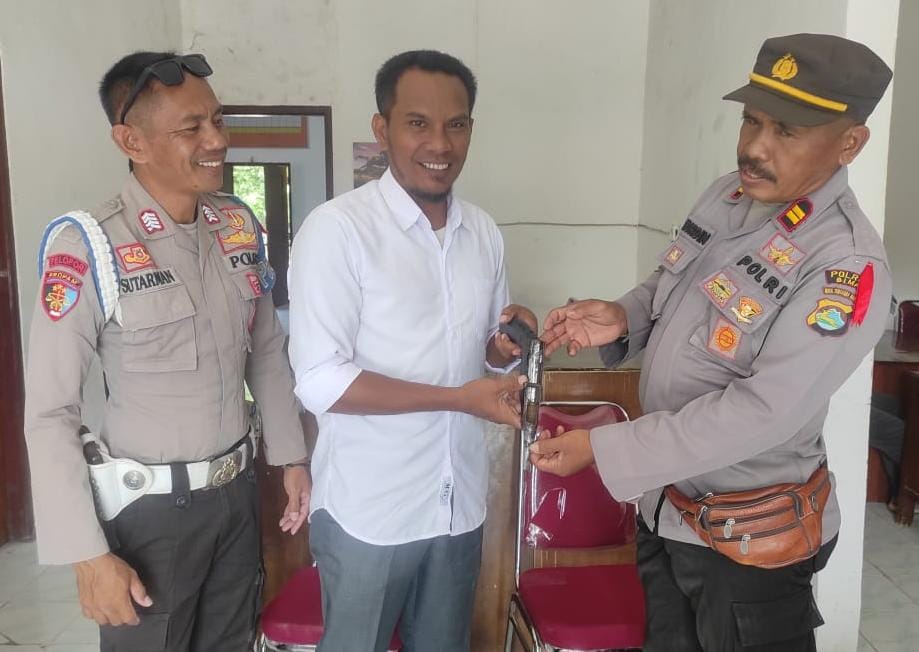 SERAHKAN SENPI: Kapolsek Bolo Iptu Nurdin menerima penyerahan sepi rakitan dari Kades Tambe Candra Nan Arif. (POLSEK BOLO FOR LOMBOK POST)