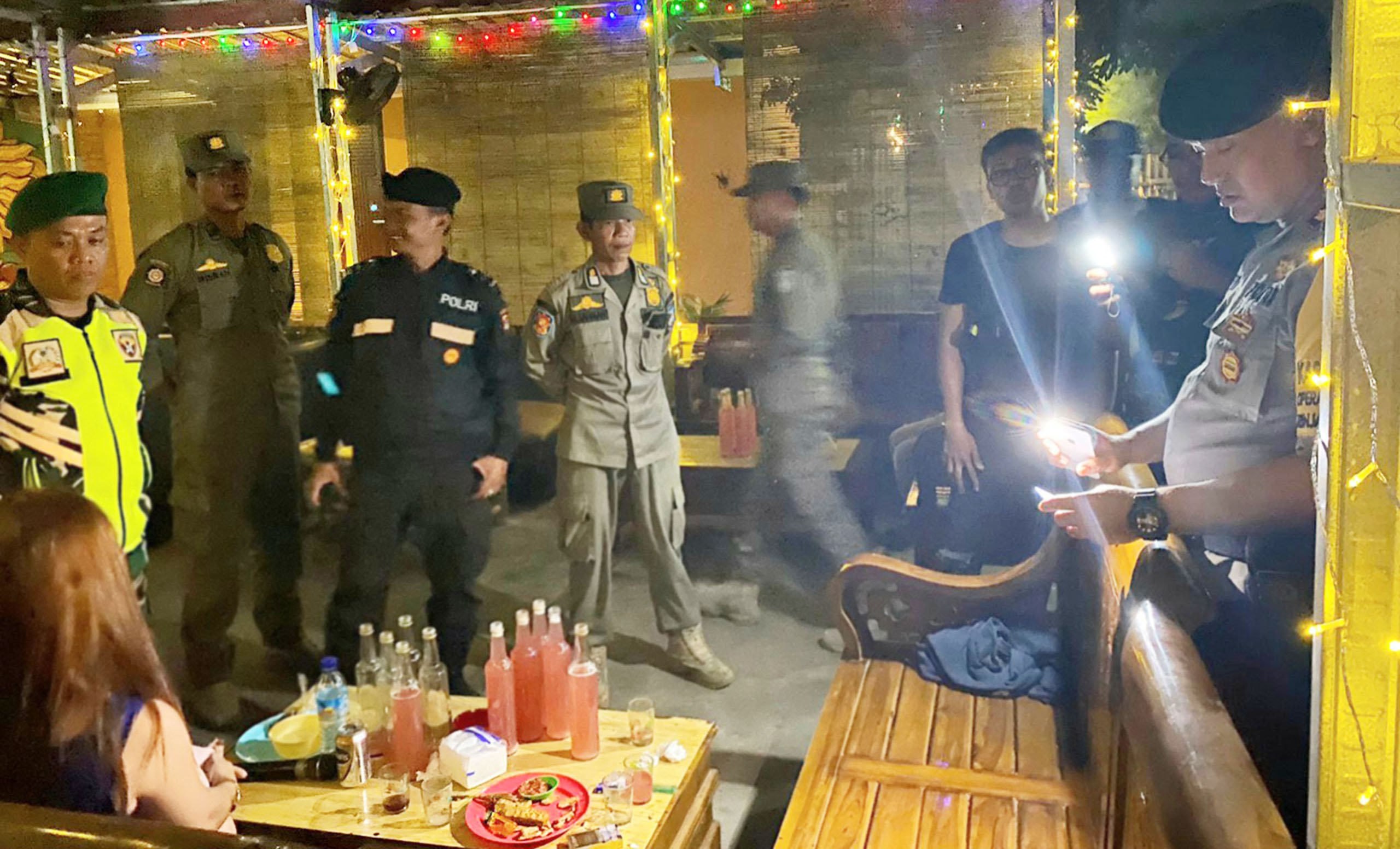 Polisi berdama tim gabungan mendatangi salah satu kafe tuak di Mataram, Sabtu malam (23/12).
