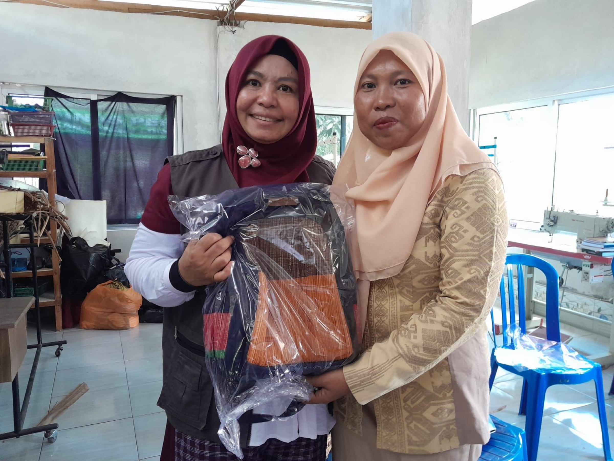 PRODUK KERAJINAN: Kepala Dinas Perindustrian NTB Nuryanti (kiri) memperlihatkan produk kerajinan eceng gondok milik perajin di Desa Batujai. (IST/LOMBOK POST)