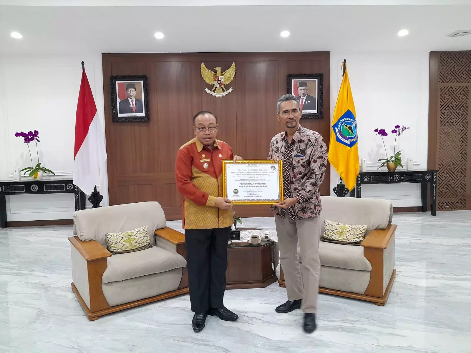 Pj Gubernur NTB H Lalu Gita Ariadi saat menerima penghargaan Ombudsman RI yang diserahkan Kepala Ombudsman RI Perwakilan NTB Dwi Sudarsono.