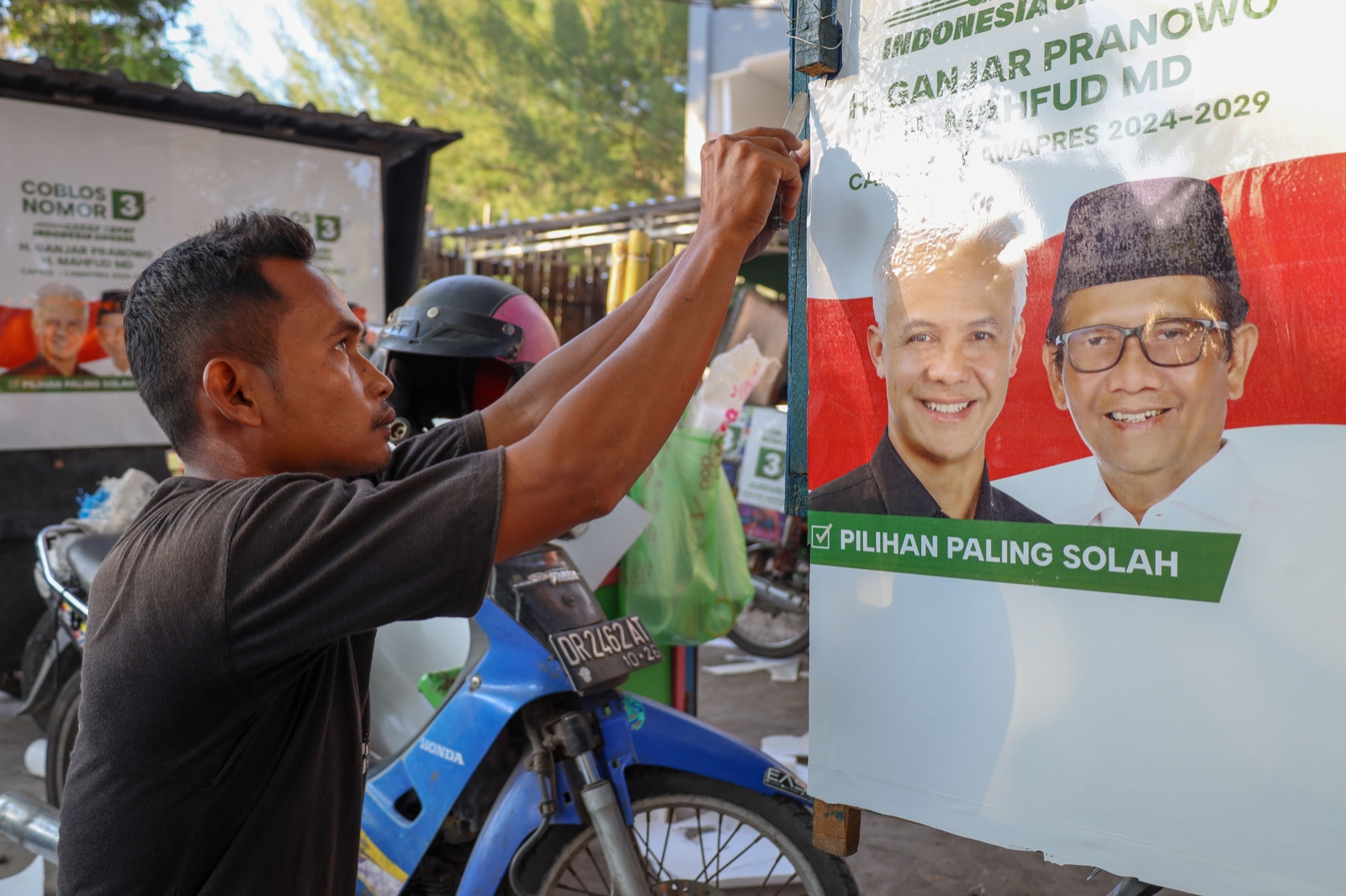 Salah seorang pedagang memasang stiker Ganjar Mahfud di gerobaknya.