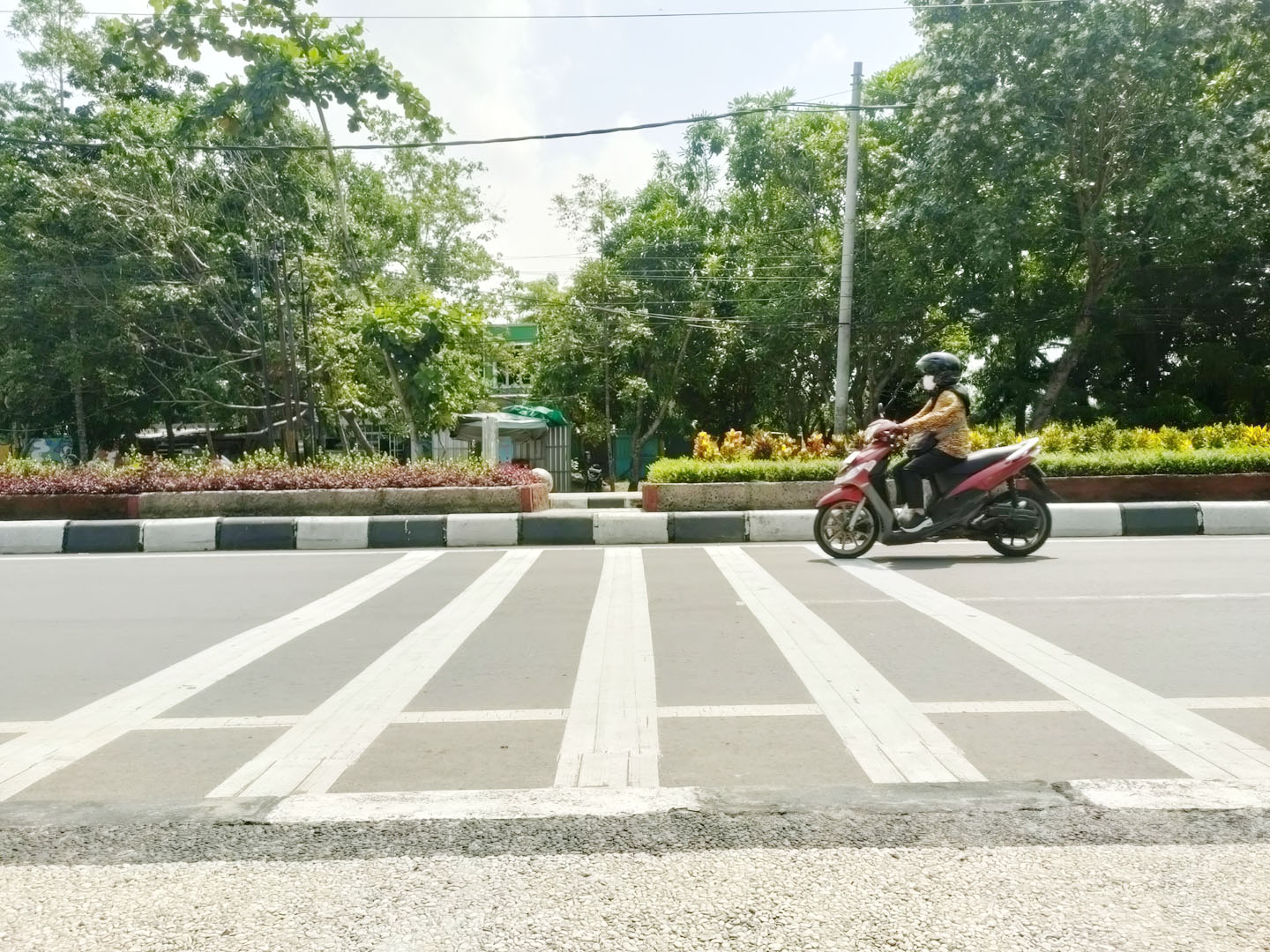 Seorang pengendara mengurangi kecepatan saat melewati pita penggaduh yang sudah terpasang di Jalan Udayana.