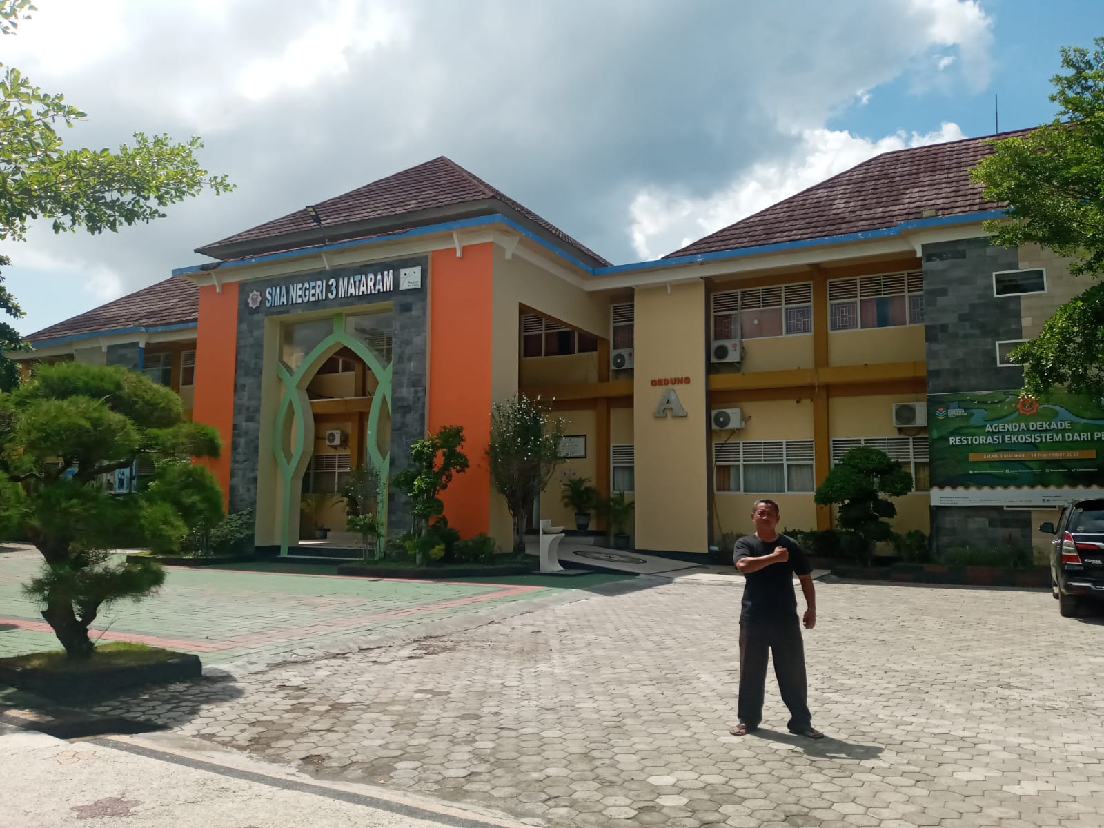 MEGAH: Seorang tenaga kependidikan SMAN 3 Mataram berdiri depan gedung sekolah setempat, belum lama ini.(ROJAI/LOMBOK POST)