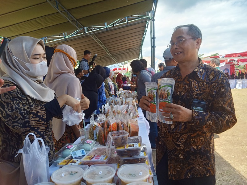 SATE KEMASAN: Salah satu pejabat tengah membeli sate Tanjung dalam kemasan dalam sebuah bazar UMKM di Lapangan Tanjung, Lombok Utara, beberapa waktu lalu.(DOK/LOMBOK POST)