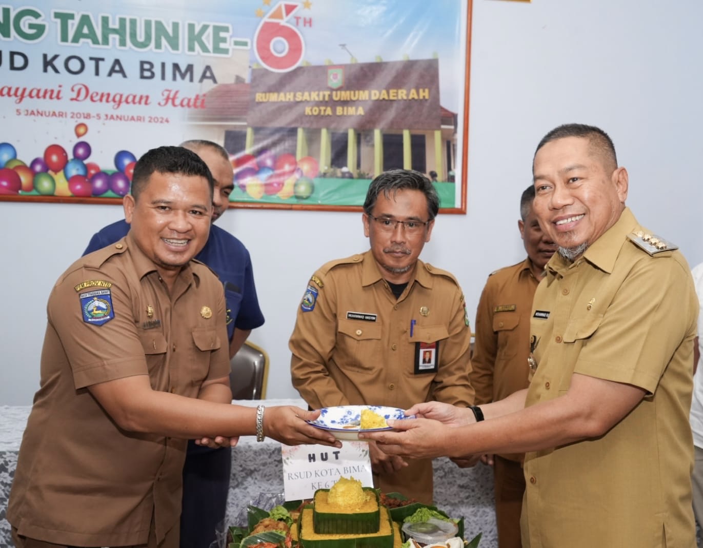 SELAMAT ULANG TAHUN: Pj Wali Kota Bima Mohammad Rum memotong tumpeng perayaan HUT RSUD Kota Bima ke-6. (PEMKOT BIMA FOR LOMBOK POST)