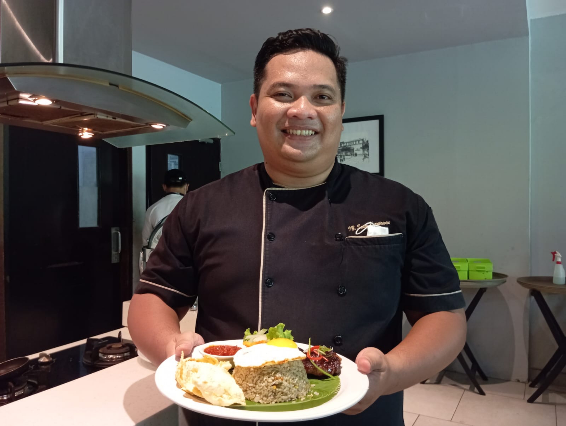 MENU PROMO: Head Chef di Hotel Santika Mataram Ida Bagus Sanis Kurniawan menunjukkan nasi goreng buntut sambal ijo, salah satu menu promo awal tahun ini. (Ferial/Lombok Post)
