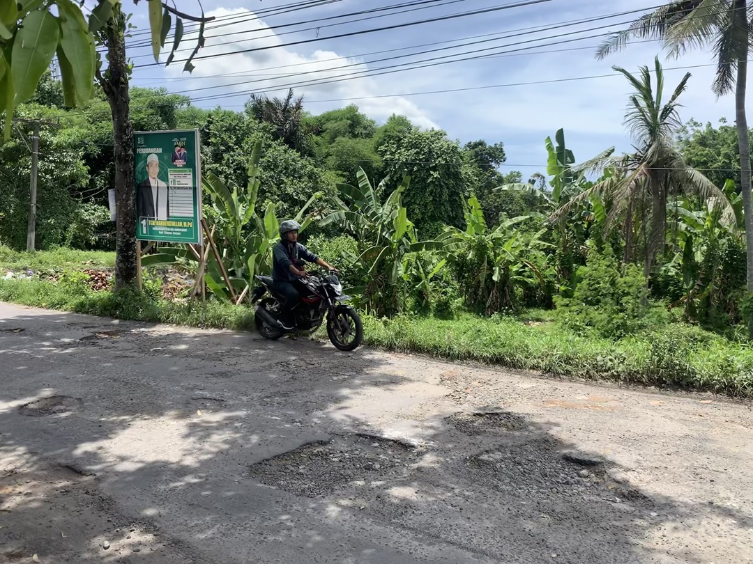 RUSAK: Seorang pengendara berupaya menghindari jalan berlubang di Desa Kuripan beberapa waktu lalu. (CHIA//LOMBOK POST)