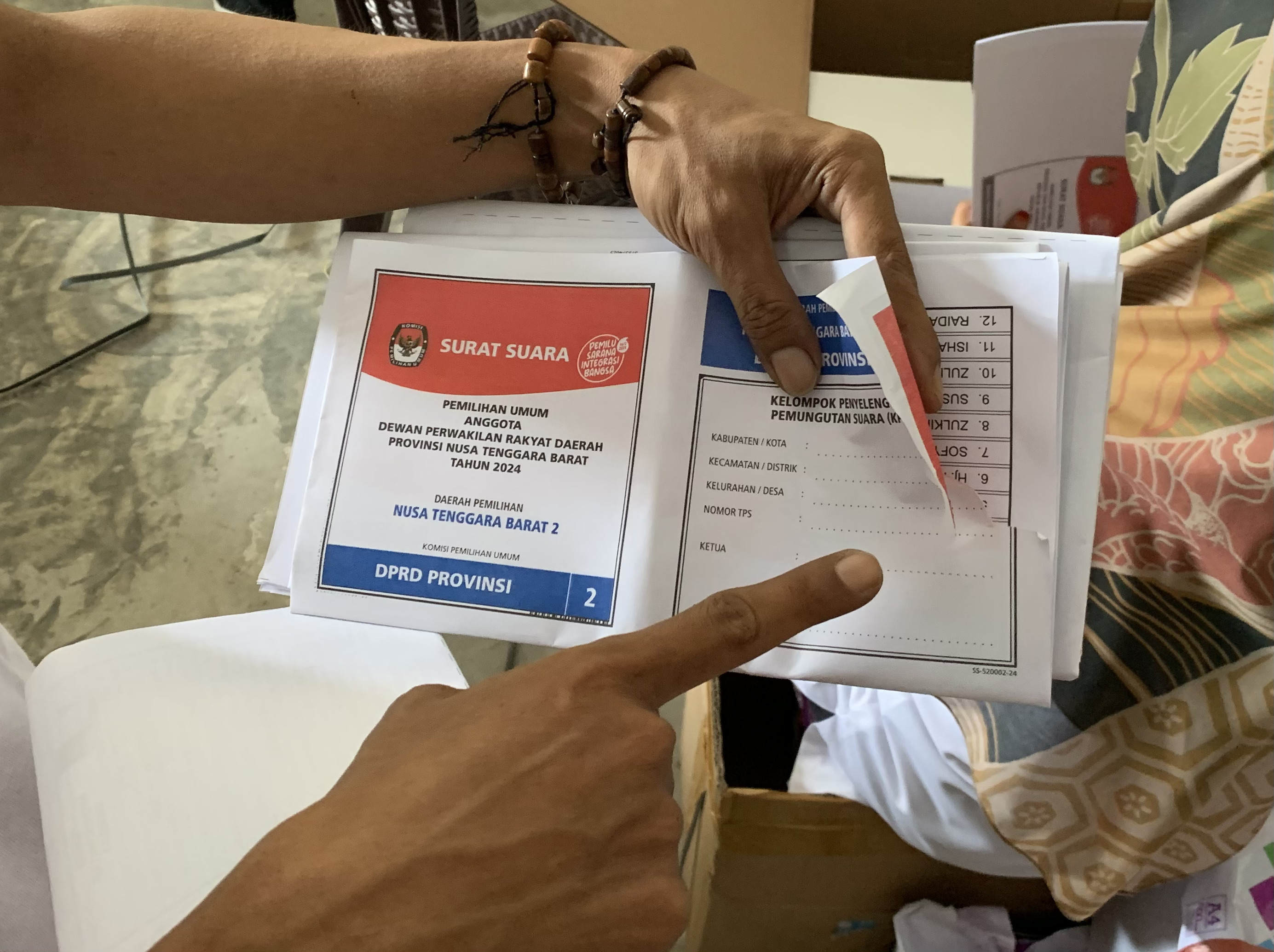 Seorang menunjukkan contoh surat suara yang rusak di gudang KPU Lobar, kemarin. (CHIA//LOMBOK POST)