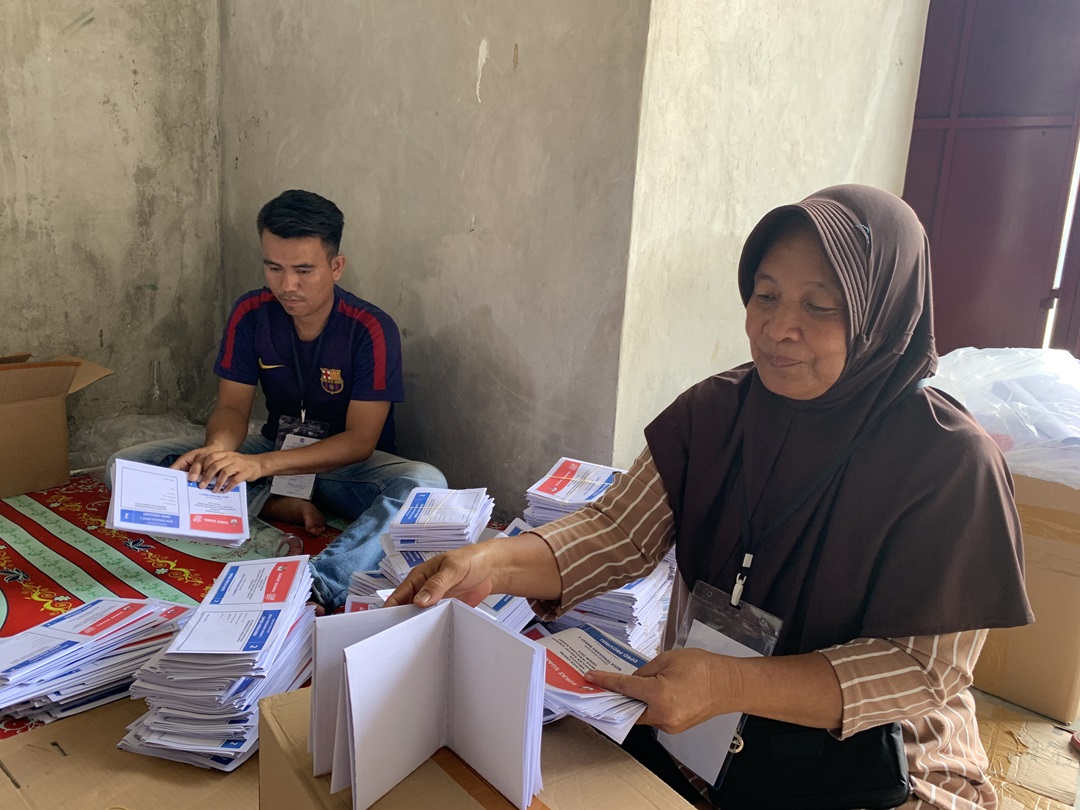 LIPAT SURAT SUARA: Petugas pelipat surat suara sedang melakukan pelipatan di gudang penyimpanan logistik KPU. (CHIA//LOMBOK POST)
