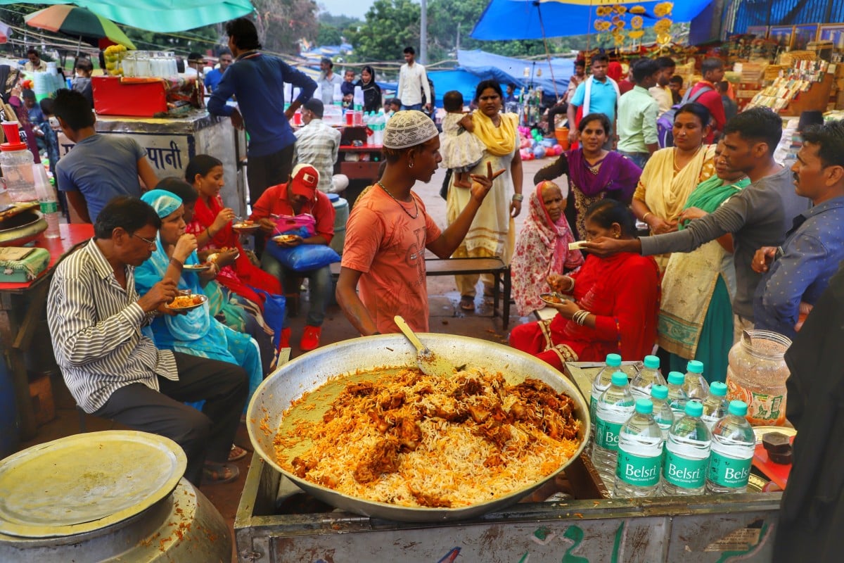 Seorang penjual Biryani berbicara dengan seorang pelanggan di Masjid Jama di Old Delhi, India. (foto : Getty Images)