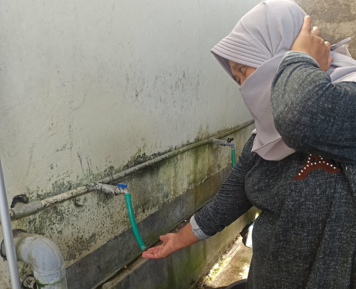 MAMPET LAGI: Sarmila, warga Dusun Mesanggok, Desa Mesanggok, Kecamatan Gerung harus mengelus dada melihat kran airnya hanya keluar angin karena gangguan distribusi air.(Farida/Lombok Post)