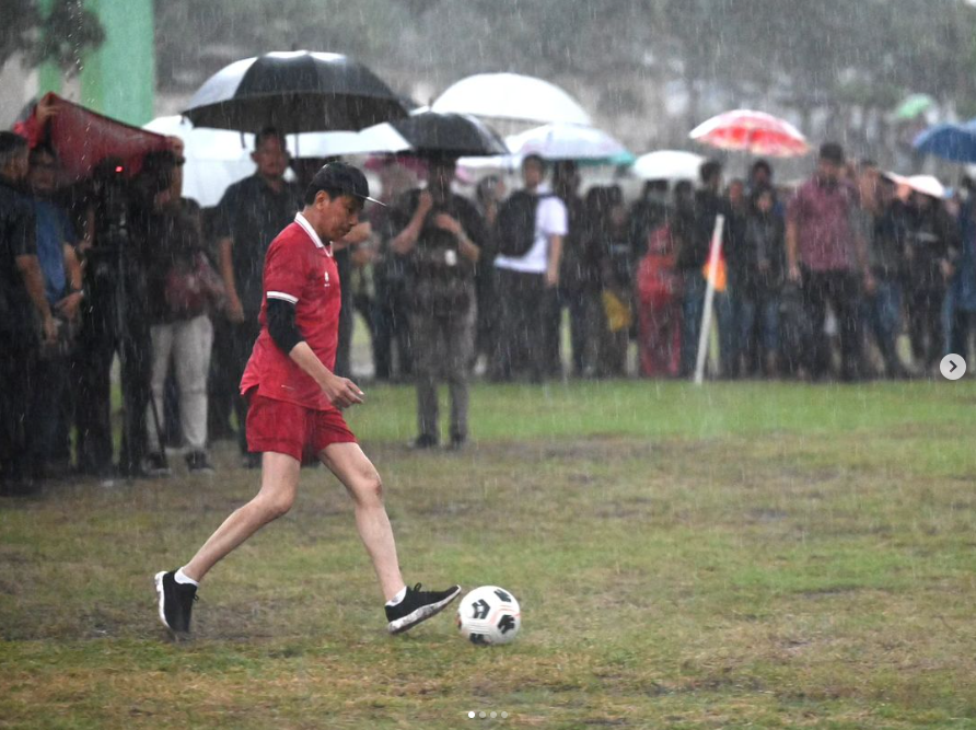 Presiden Jokowi saat bermain bola dalam guyuran hujan di Jogja. (tangkapan layar IG Jokowi)