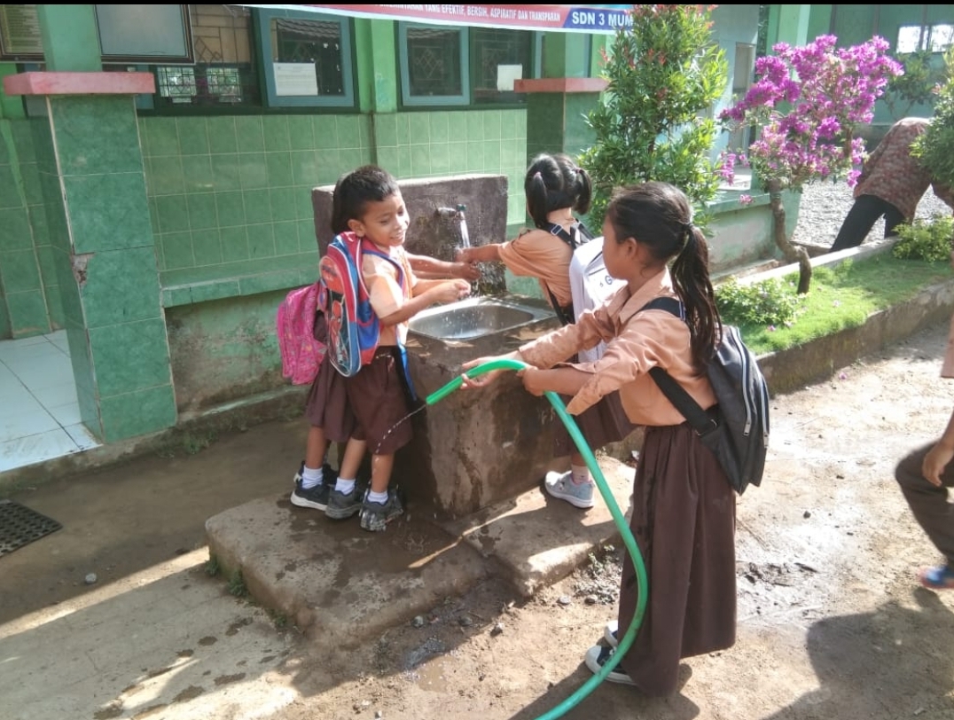 GUNAKAN AIR: Beberapa siswa mendapatkan pendidikan dalam penggunaan air secara bijak di salah satu sekolah Desa Mumbul Sari, Kecamatan Bayan, beberapa waktu lalu.(HARI FOR LOMBOK POST)