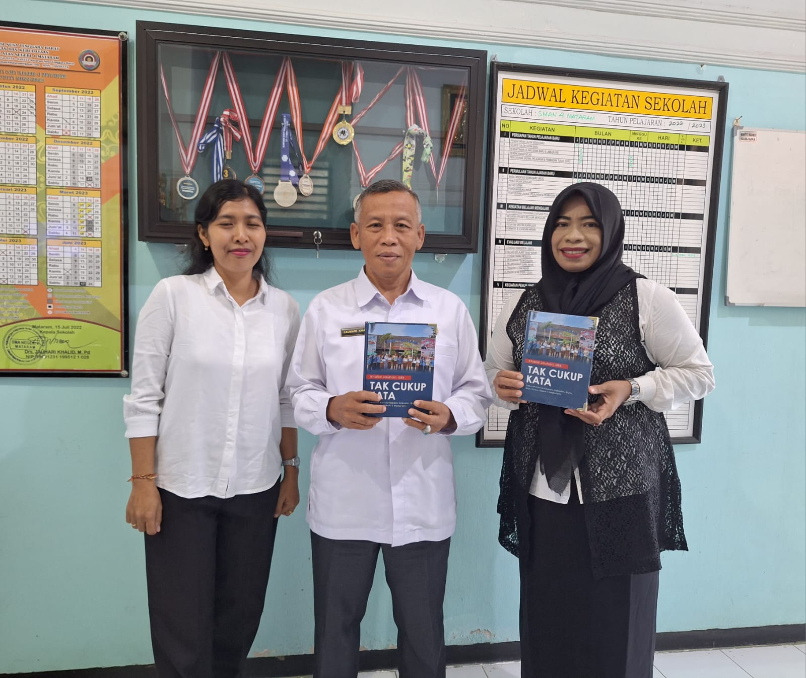 HASIL KARYA: Kepala SMAN 4 Mataram H Jauhari Khalid (tengah) bersama kordinator literasi menunjukkan buku hasil karya siswa dan guru di sekolah setempat. (EMILIYATI FOR LOMBOK POST)