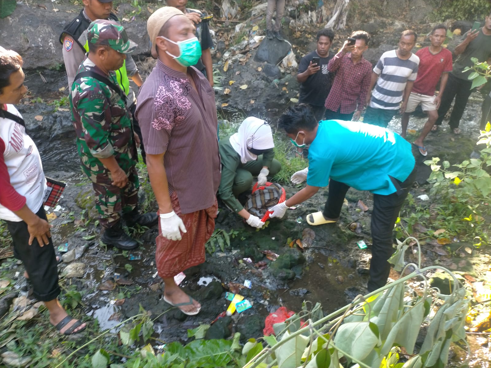 EVAKUASI: Tim medis dan aparat  mengevakuasi mayat bayi perempuan yang ditemukan di kali perbatasan antara Dusun Malang Barat dengan Dusun Tunjang Selatan, Desa Paokmotong, Kecamatan Masbagik, Lotim