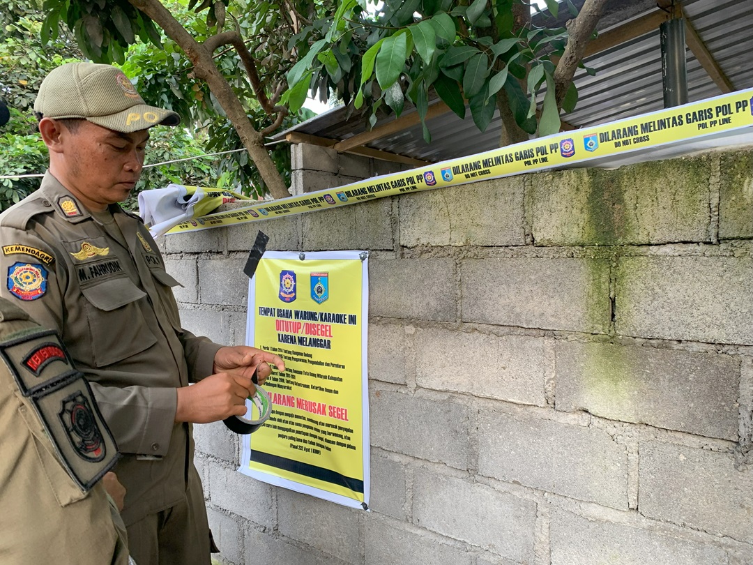 DISEGEL: Petugas Satpol PP menyegel salah satu warung yang menujual miras tradisional di Kuripan beberapa waktu lalu. (CHIA/LOMBOK POST)