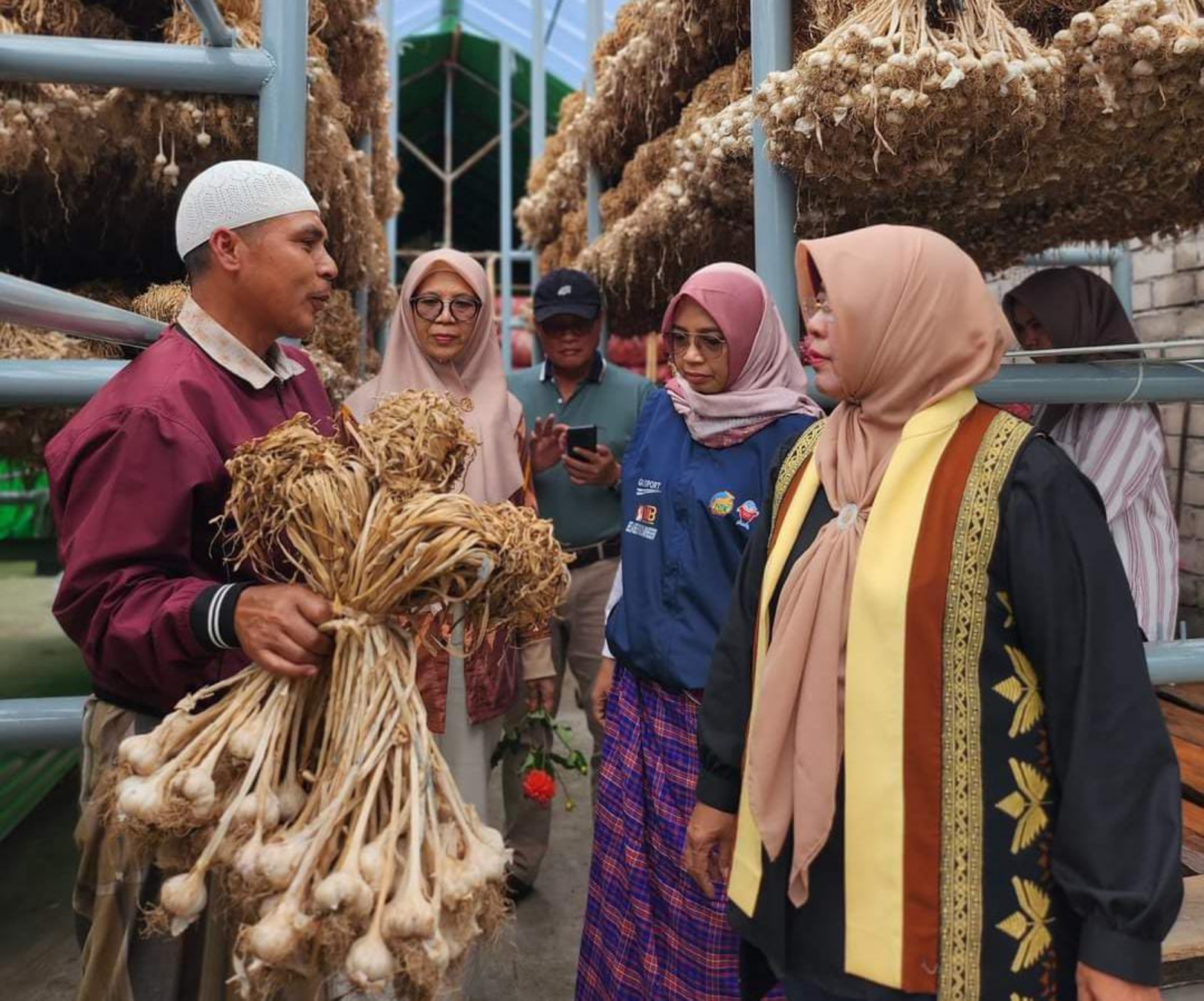 SENTRA BAWANG PUTIH: Pj Ketua Dekranasda NTB Hj Lale Prayatni Gita Ariadi (kanan) dan Kepala Dinas Perdagangan NTB Baiq Nelly Yuniarti (dua kanan) saat mengunjungi salah satu petani. (IST/LOMBOK POST)