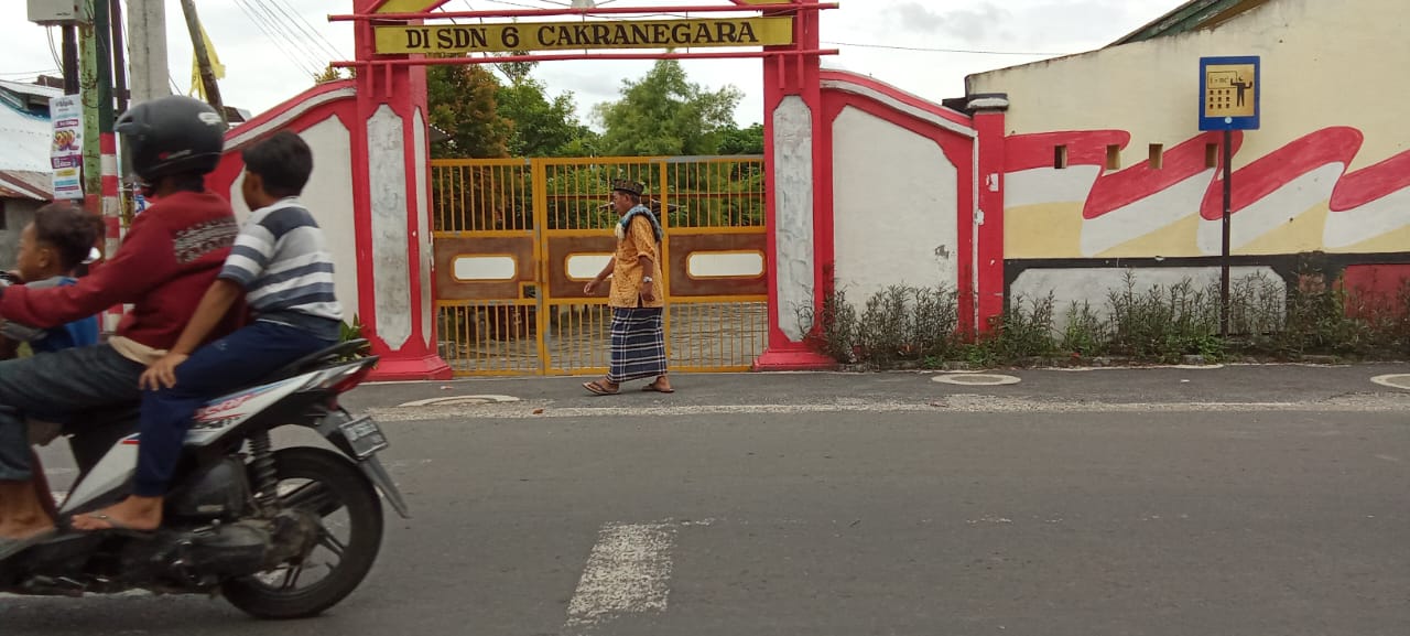 ROJAI/LOMBOK POST AKAN DIUBAH: Seorang pengendara melintas di depan SDN 6 Cakranegara, kemarin. Sekolah ini berada di wilayah Kecamatan Sandubaya namun nama Kecamatan Cakranegara yang digunakan.