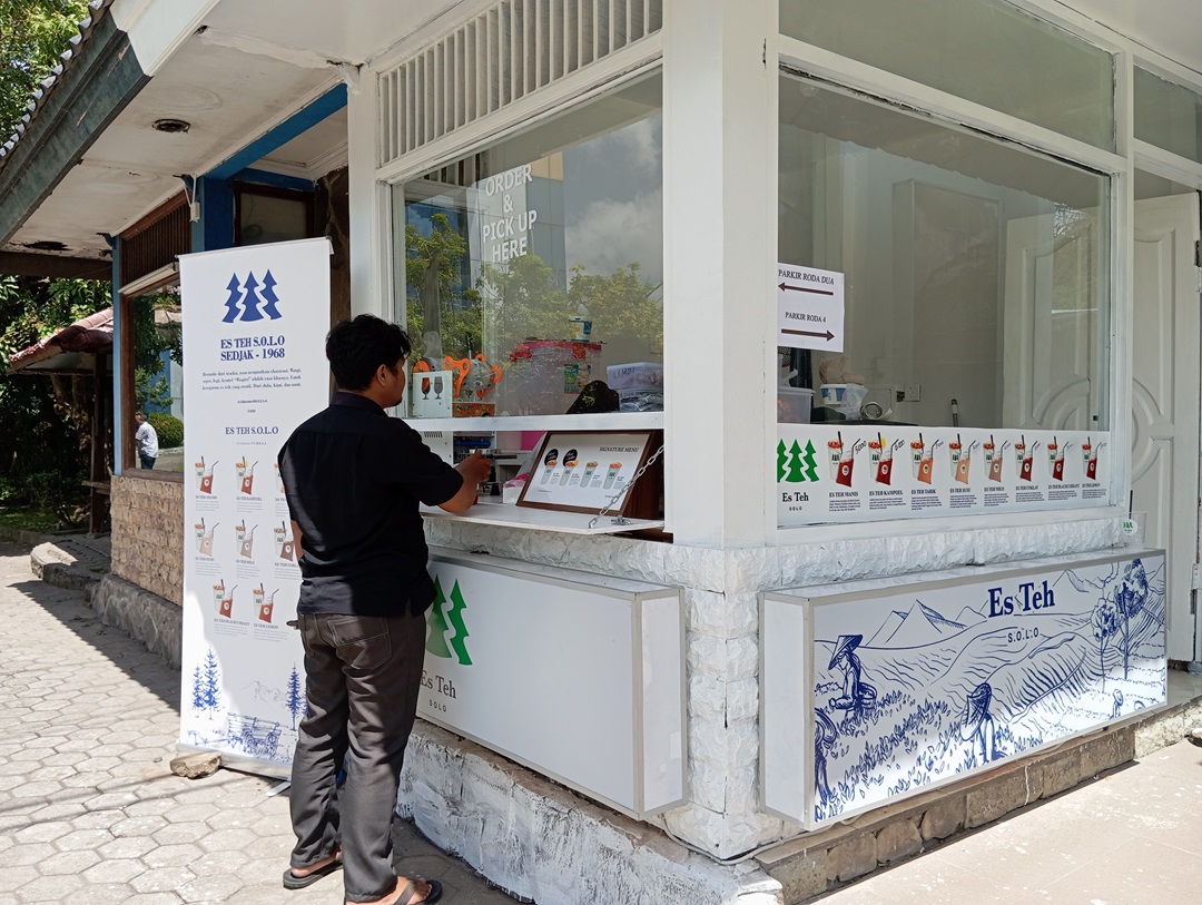 PELUANG WARALABA: Salah seorang warga tengah membeli Es Teh S.O.L.O, di depan Kantor Graha Pena Lombok, Turida. (FERIAL/LOMBOK POST)