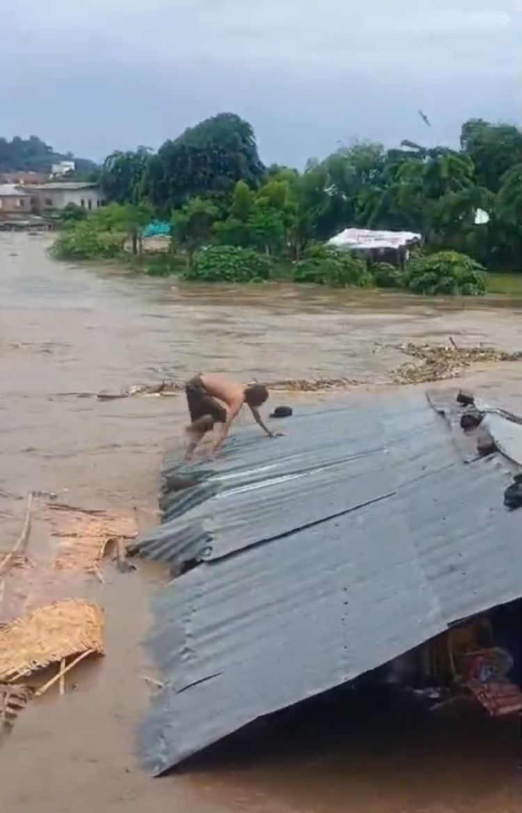 BANJIR MENERJANG: Seorang warga berusaha menyelamatkan diri dari amukan air bah, saat banjir bandang melanda Sumbawa Besar, Kabupaten Sumbawa, Jumat sore (9/2).