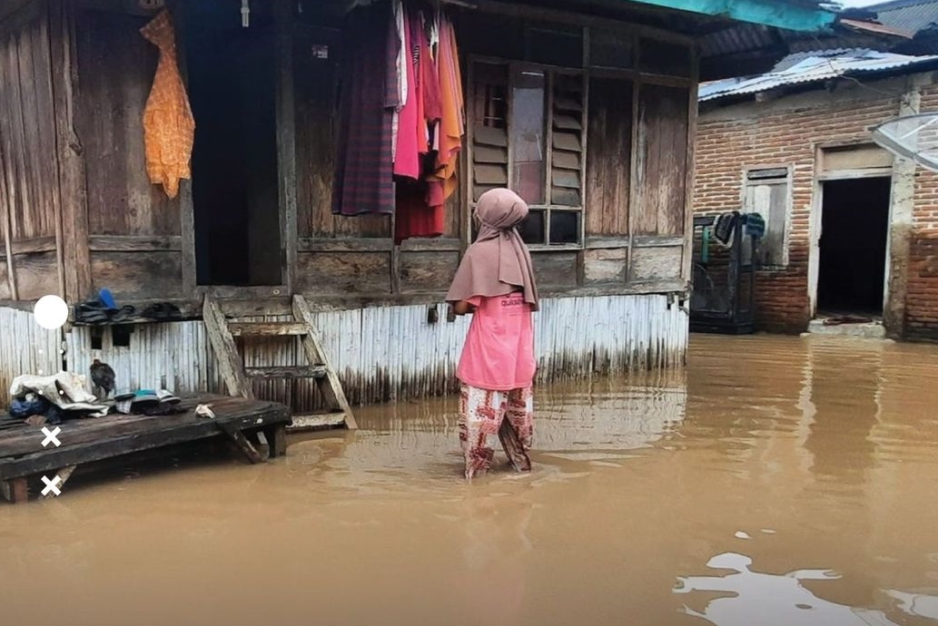 Seorang rumah warga tergenang banjir, yang diakibatkan hujan dengan intensitas sedang-lebat yang disertai kilat atau petir dan angin kencang, di salah satu desa di Kabupaten Bima, Jumat (9/2).