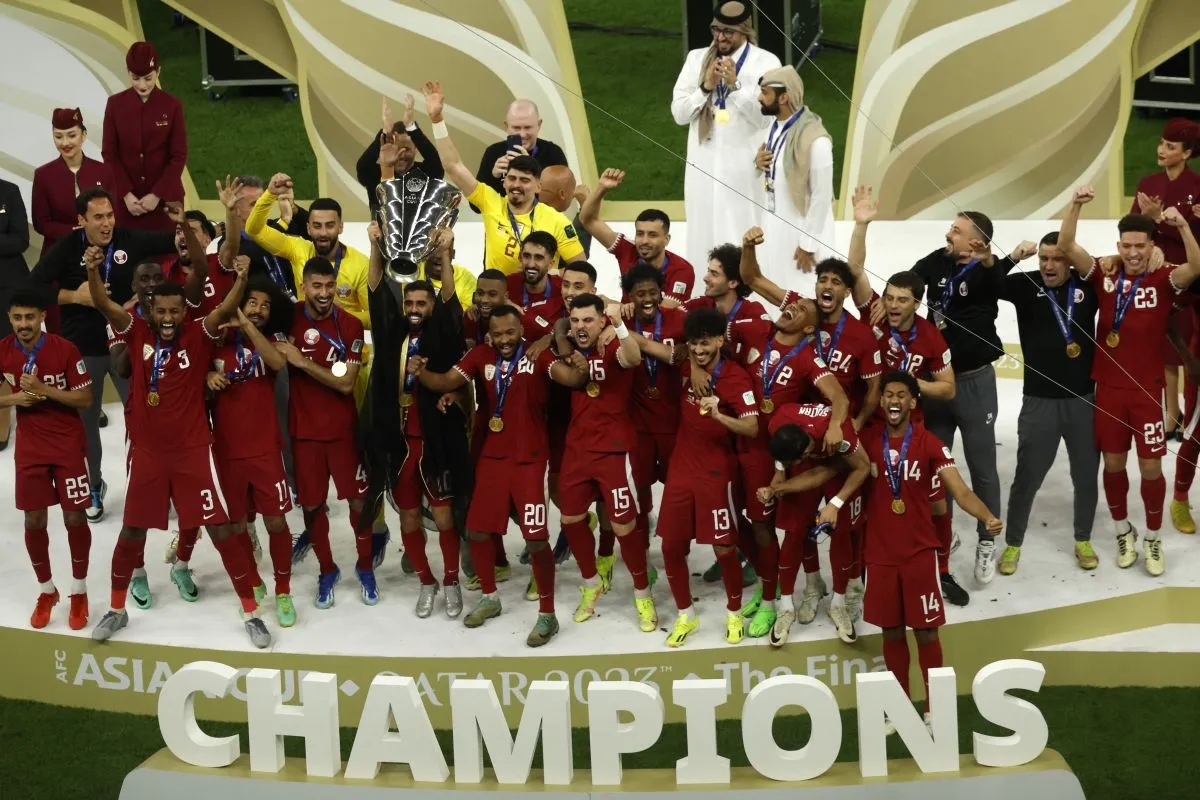 Pemain Qatar Hassan Al-Haydos mengangkat trofi juara Piala Asia 2023. (foto : AFP)