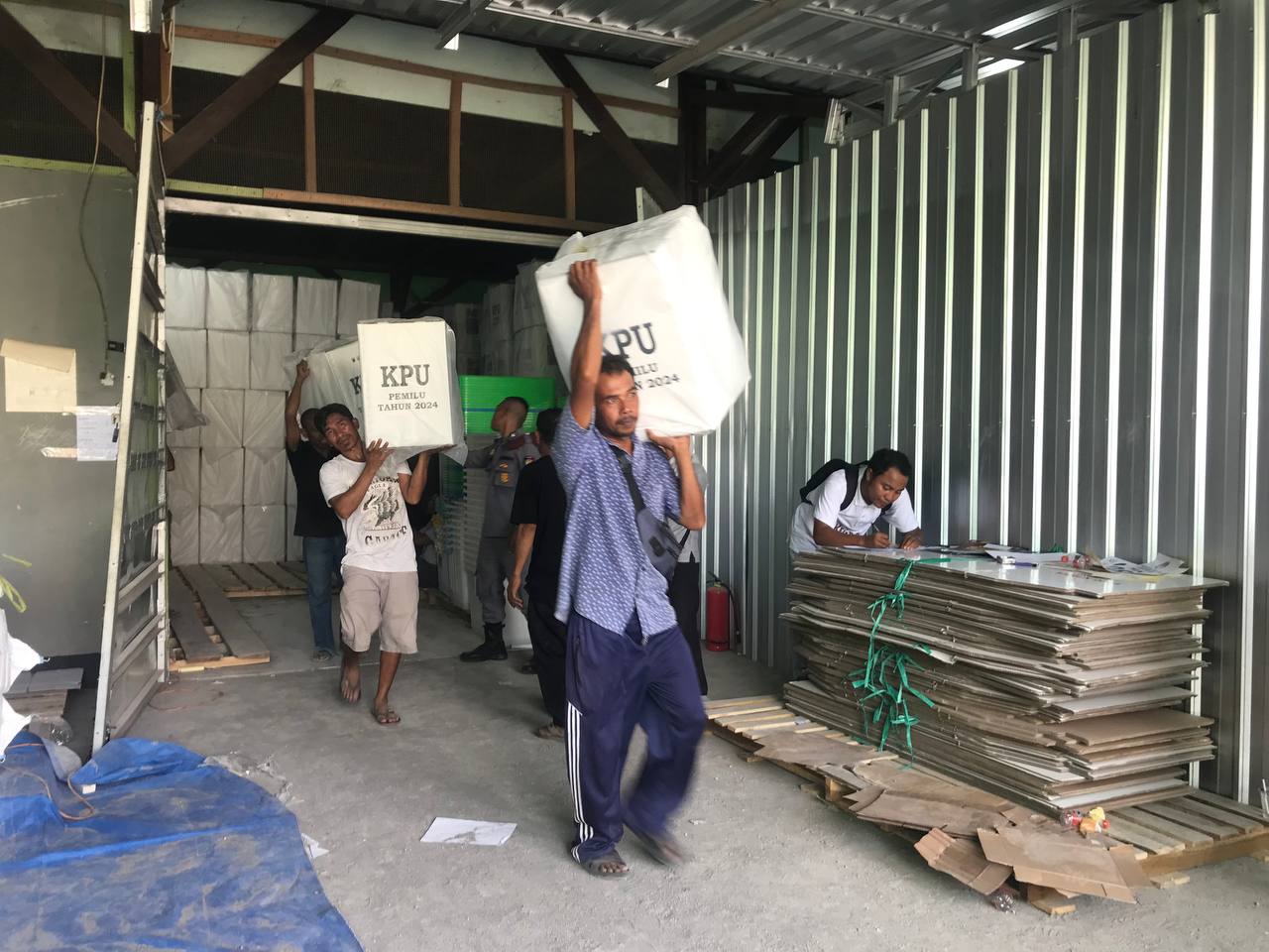 BAWA LOGISTIK: Petugas Gudang Logistik KPU membawa logistik yang akan dinaikkan ke truk untuk didistribusikan kelima kecamatan se-KLU di Gudang Logistik KPU, Tanjung, Selasa (13/2).