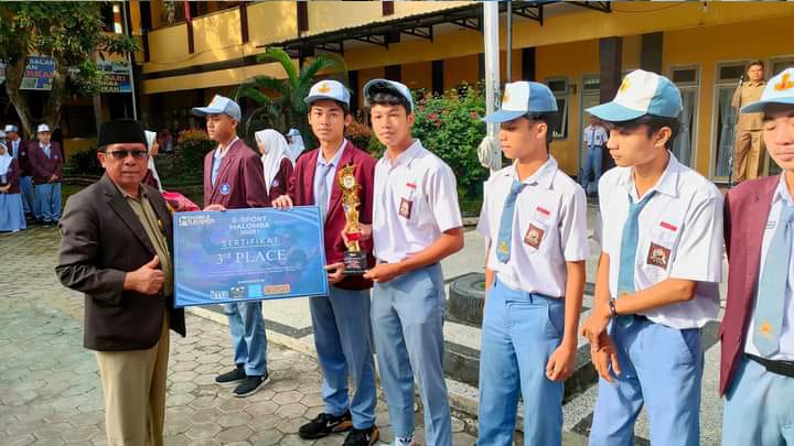 REWARD: Kepala SMAN 1 Narmada Hulwani memberikan penghargaan kepada siswa berprestasi di sekolah setempat. (HULWANI FOR LOMBOK POST)