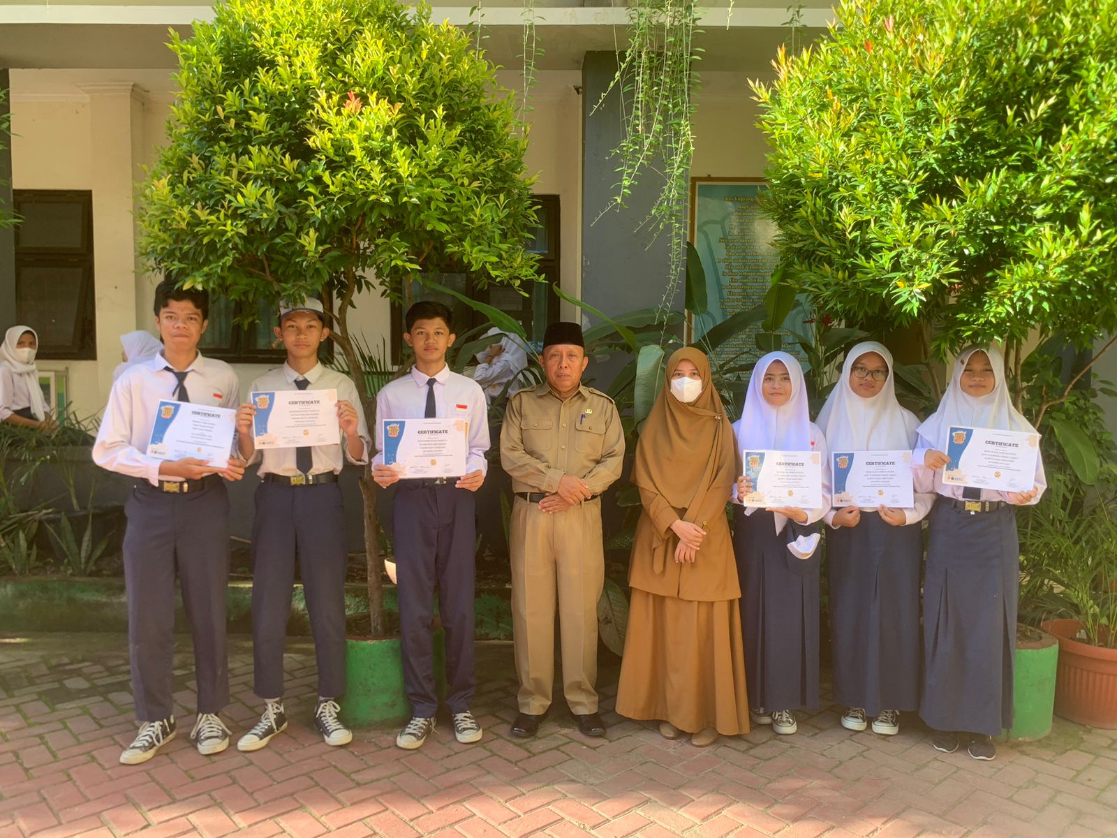 MEMBANGGAKAN: Siswa SMPN 6 Mataram yang masuk sepuluh besar Microgrant Competition bersama kepala sekolah dan guru pembina di halaman sekolah, belum lama ini.(SPENA FOR LOMBOK POST)