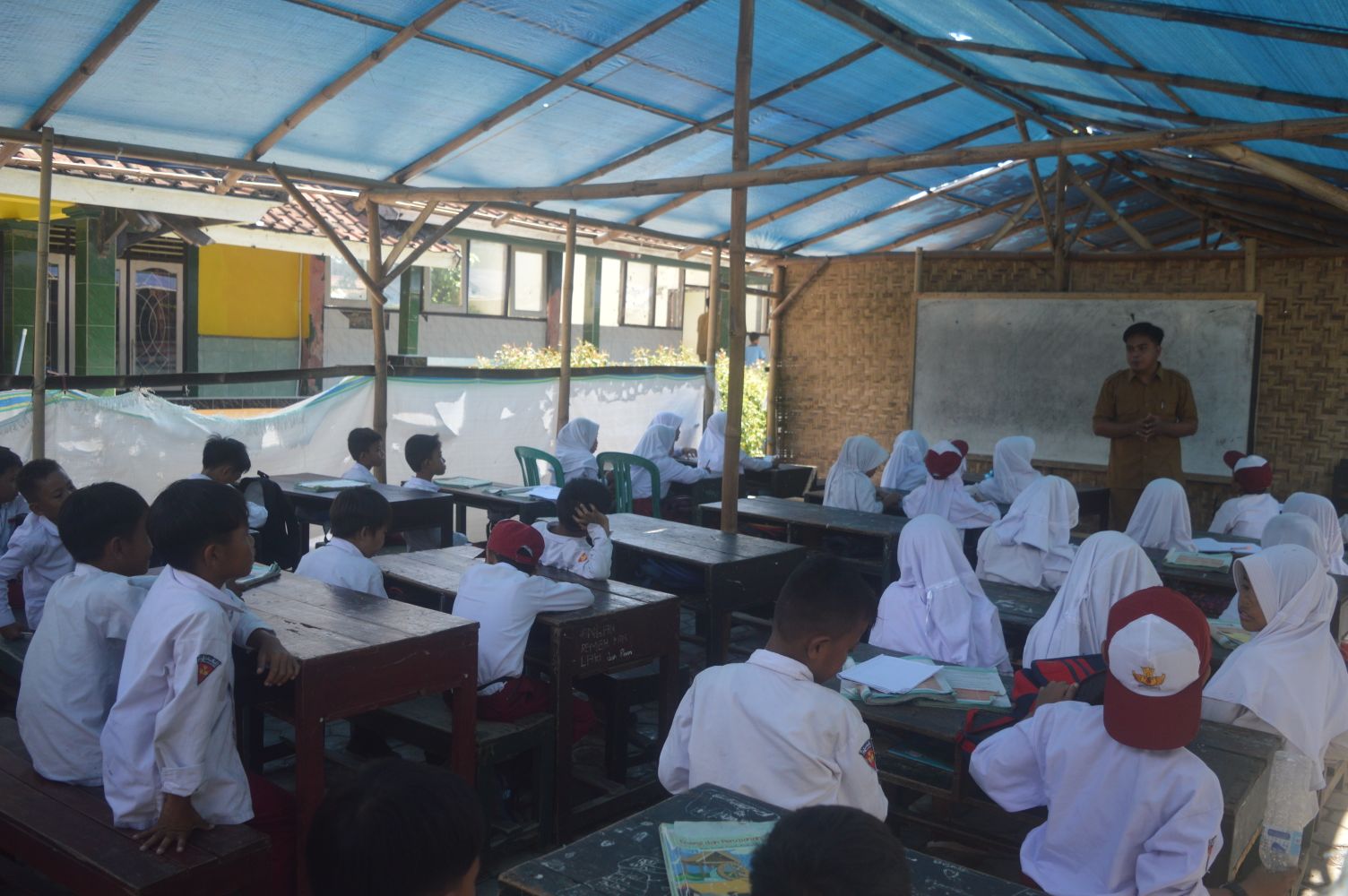 Seorang guru sedang memberikan materi pembelajaran kepada siswa-siswi kelas 5 di SDN Montong Ara, Desa Menemeng, Kecamatan Pringgarata, Lombok Tengah.