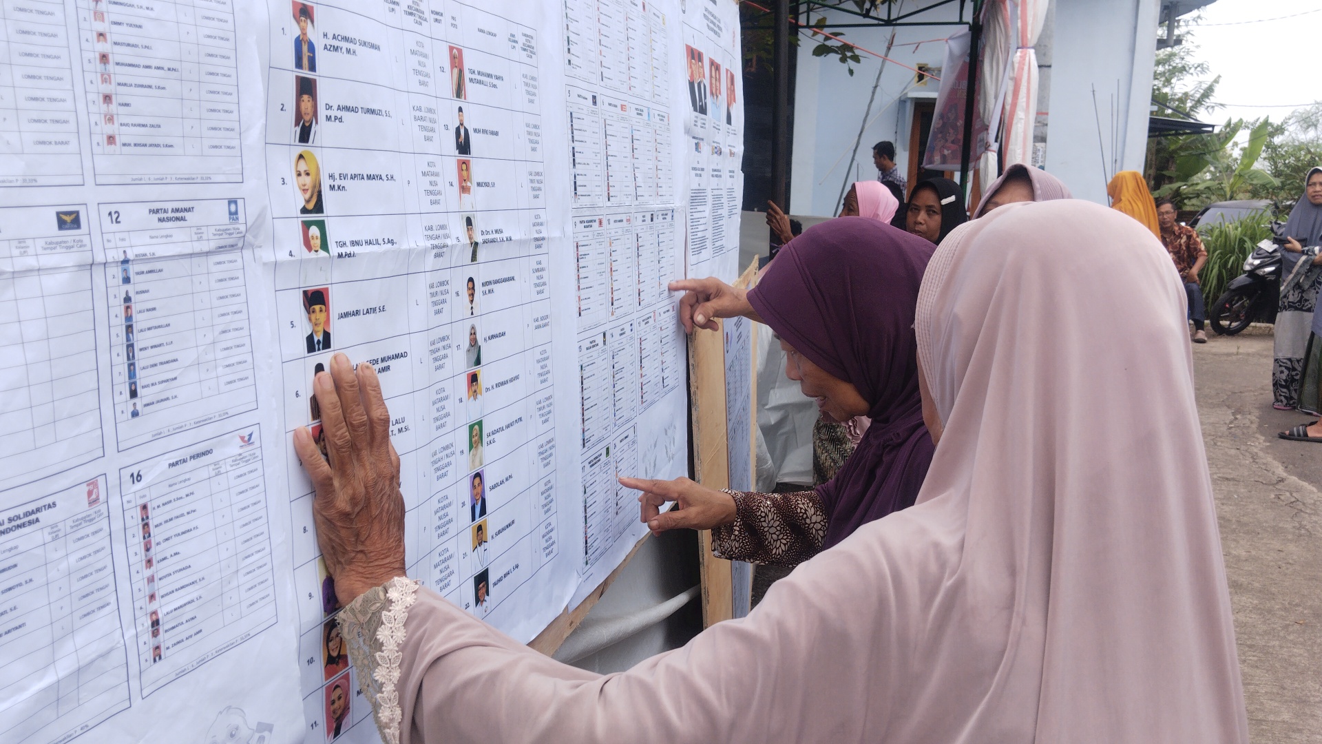 Sejumlah pemilih melihat daftar nama para calon presiden dan legislatif di TPS 27 Lendang Ape, Praya, Loteng, Jumat (23/2).