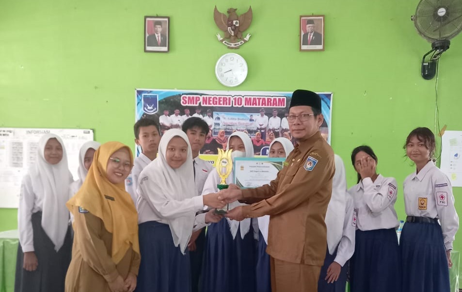 REWARD: Kepala SMPN 10 Mataram H Chamim Tohari memberikan reward kepada siswa berprestasi di sekolah setempat. (SPENTEN FOR LOMBOK POST)