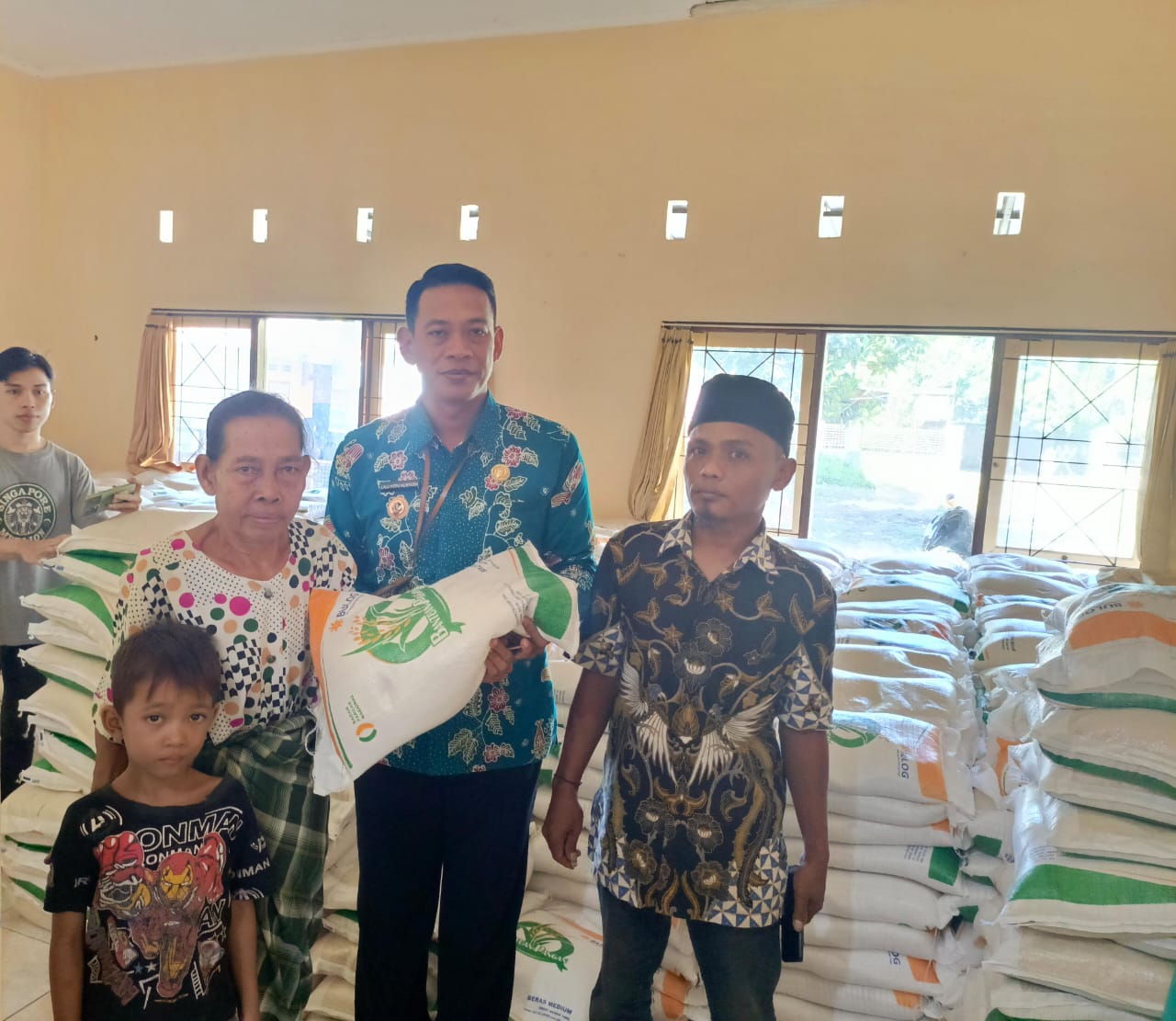Lurah Mandalika Lalu Heru Nuryadin secara simbolik menyerahkan bantuan beras CPP pada warga, didampingi Kaling Gerung Sayo Indah Sahli.
